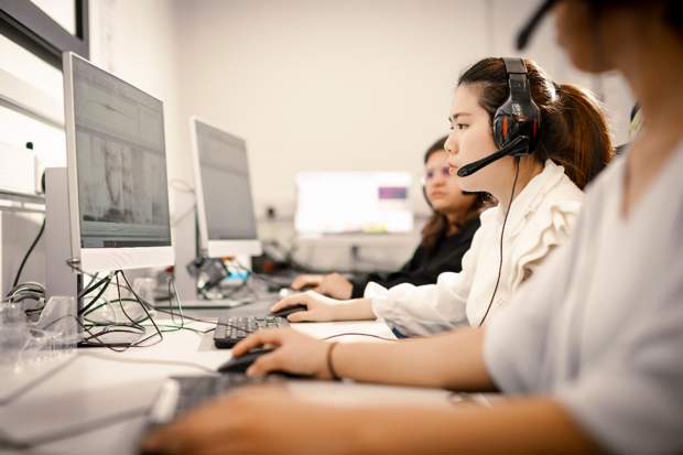 Students in a computer lab wearing headsets