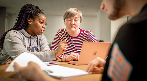 Two students working on a laptop