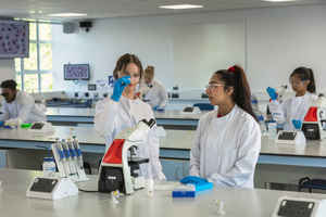 Two students looking at a microscope slide